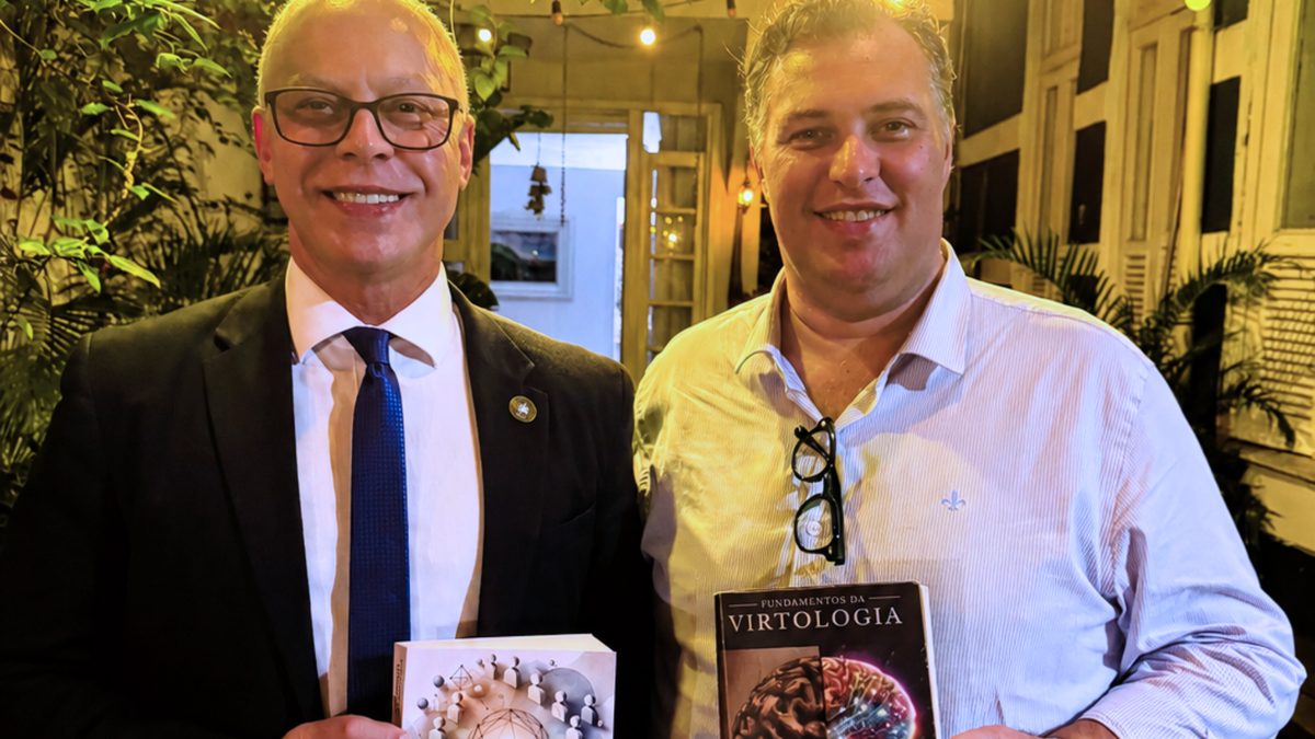 Eduardo Casarotto ao lado de Victor Cesar, que segura os livros Sistemas Humanizados e Fundamentos da Virtologia.