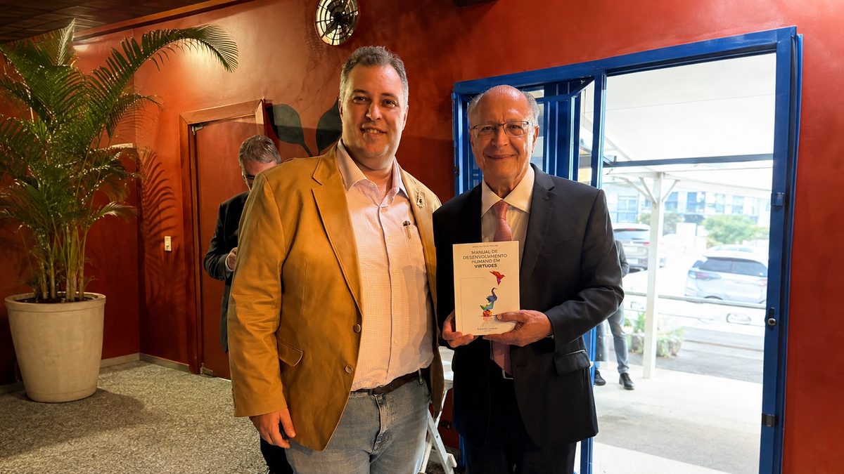 Eduardo Casarotto ao lado de Geraldo Alckmin, que segura um exemplar do Manual de Desenvolvimento Humano em Virtudes.