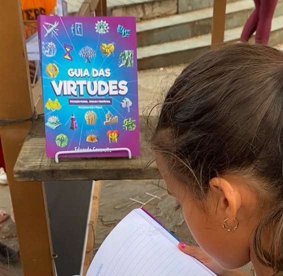Criança segurando um exemplar do Guia das Virtudes.